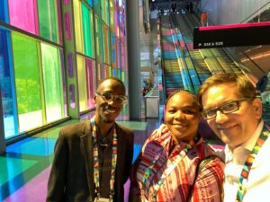 A selfie with three people in a colorful hallway