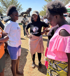 A small group of young people standing outside, talking